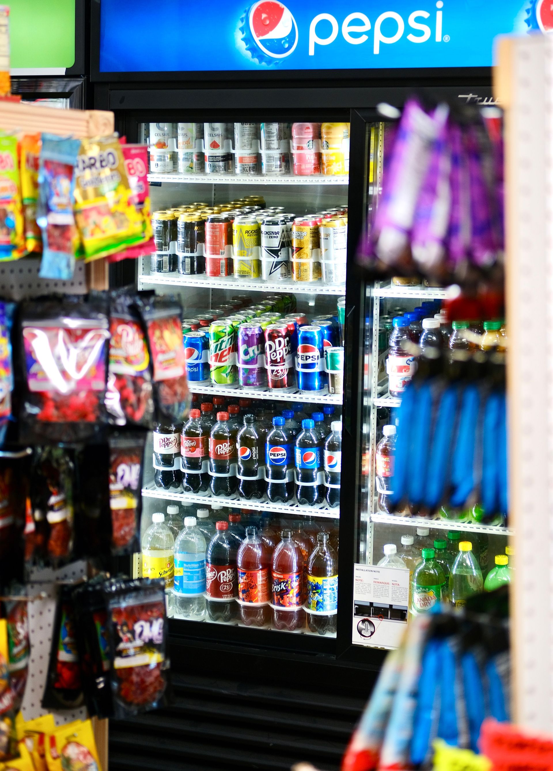 Refrigerated display of assorted beverages in a store aisle.